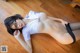 A woman laying on the floor wearing glasses and a white shirt.