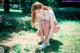 A woman tying up her shoes in a park.