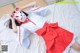 A woman in a red and white kimono laying on a bed.