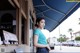 A woman standing in front of a store looking out the window.