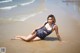 A woman in a bathing suit laying on the beach.