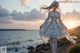 A woman in a white dress standing on a beach.