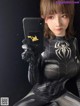 A woman in a spider suit holding up a phone case.